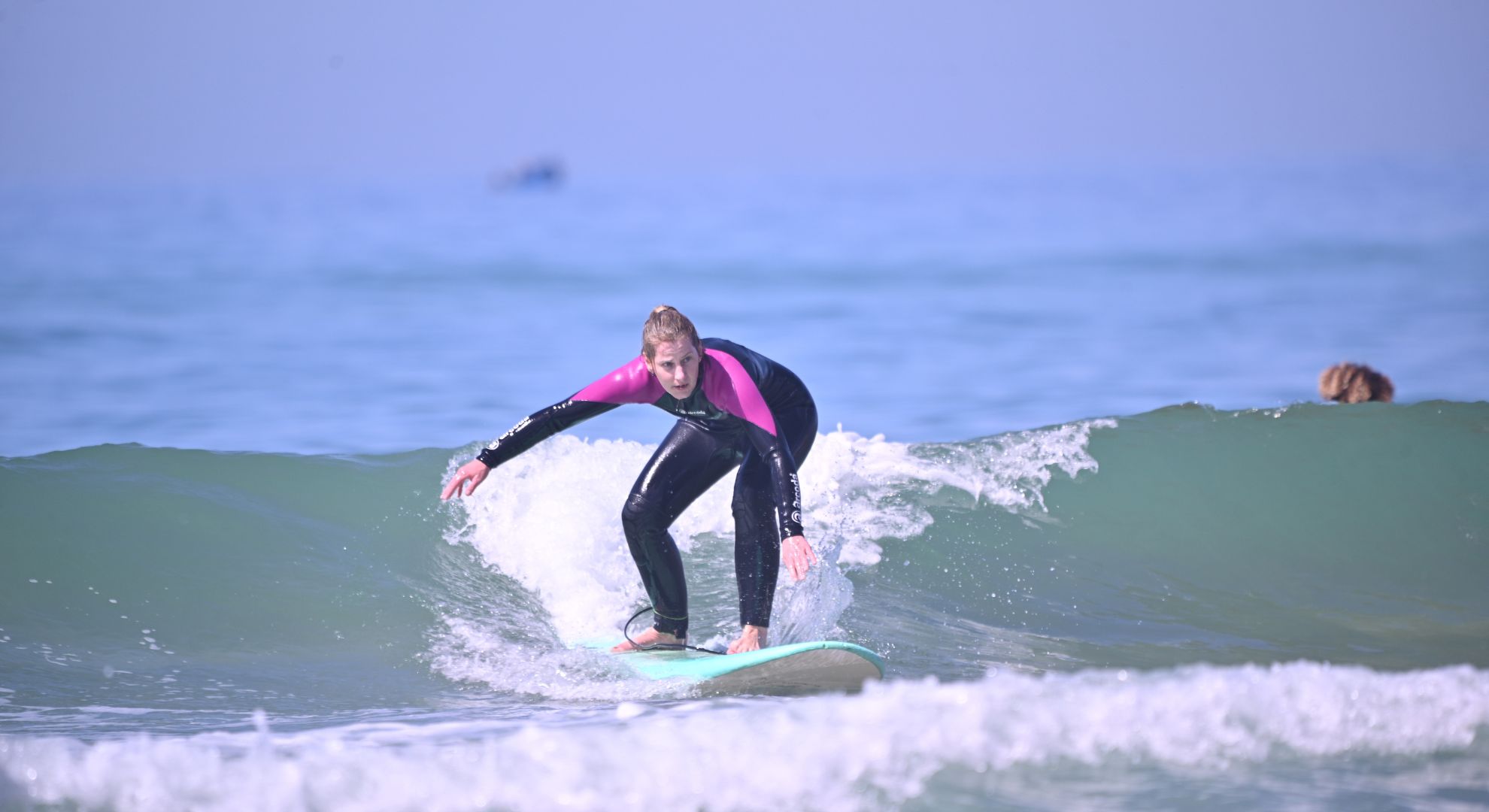 Beginner surfer standing up on a small wave